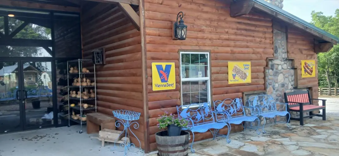 Blue ironwork chairs outside the log building at Medicine Bow Farms.